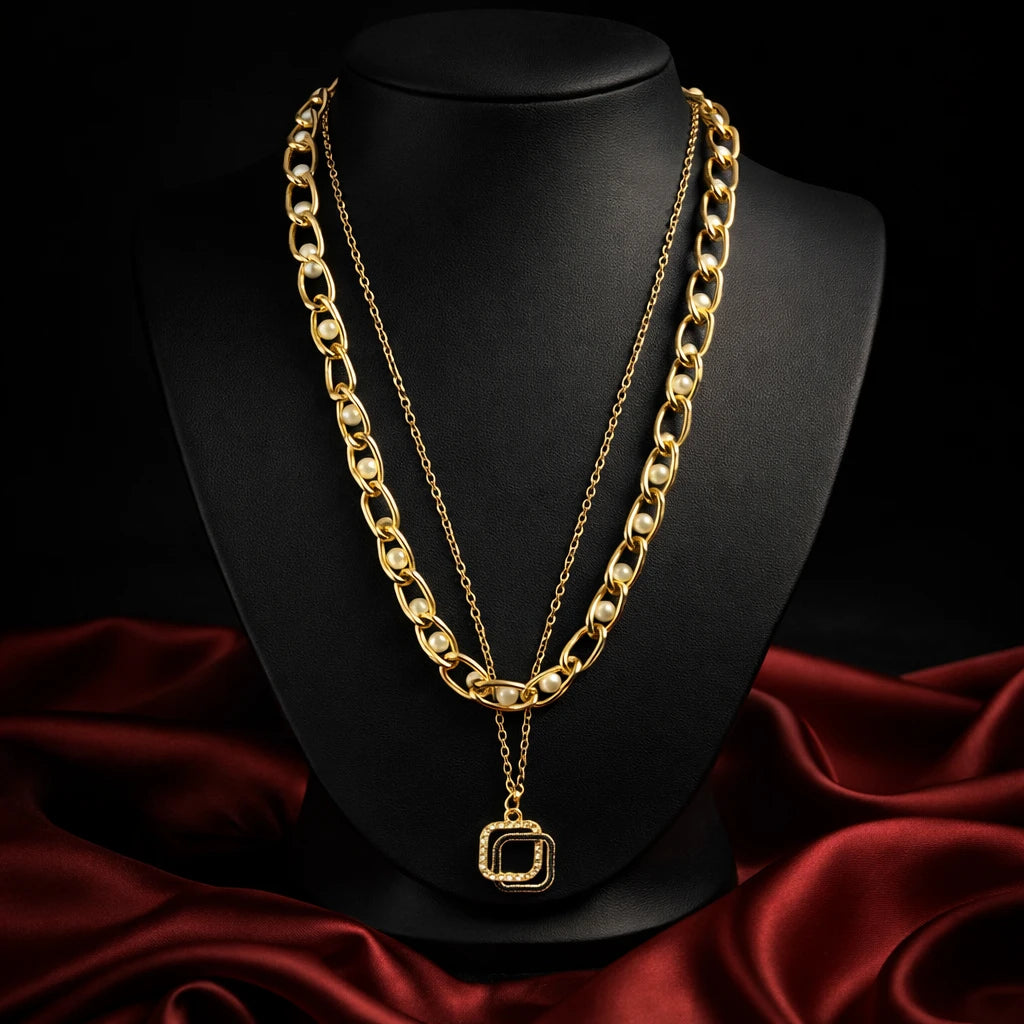 Gold chain necklace on a black mannequin bust with red fabric background