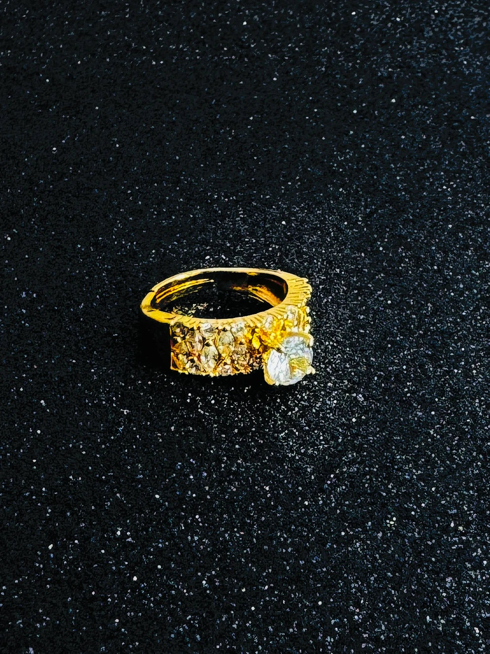 Gold ring with a large round-cut central diamond and multiple smaller diamonds set along the band.